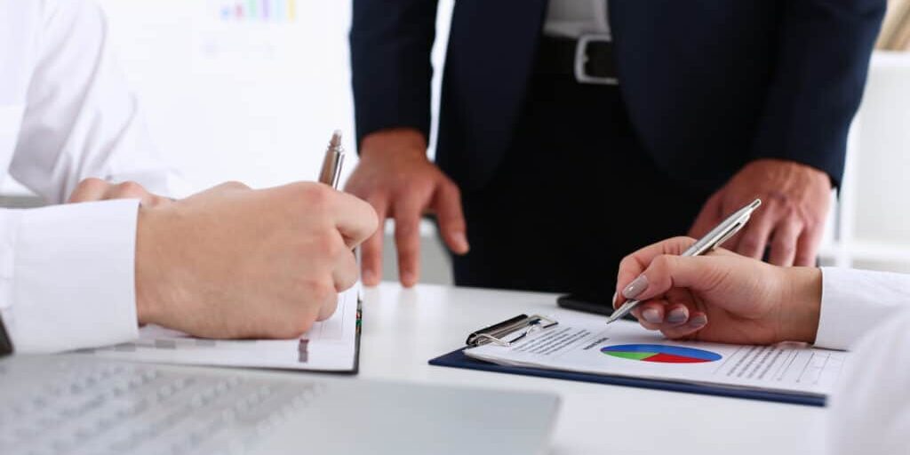 Group of people hold silver pen ready to make note in opened notebook sheet closeup. Training course, university practice homework, school or college exercise, secretary table management concept