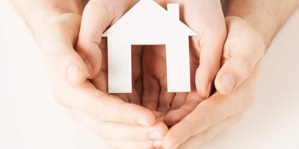 woman and hands with paper house pisture of man and woman hands holding paper house